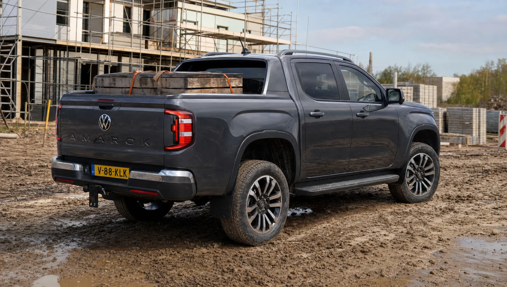 Een Volkswagen Amarok staat bij een werkterrein met zicht op bandenprofiel, wielkastvrijloop en belading in de laadbak.