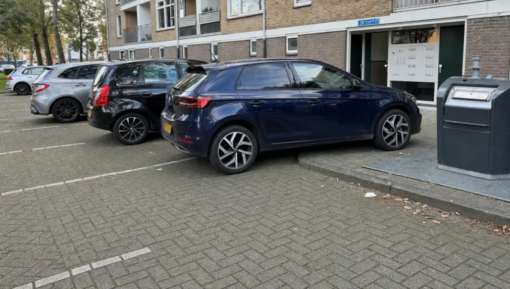 Geparkeerde auto’s in een stadsparkeerstraat tonen hoe velgbescherming helpt tegen stoeprandschade en vuil.