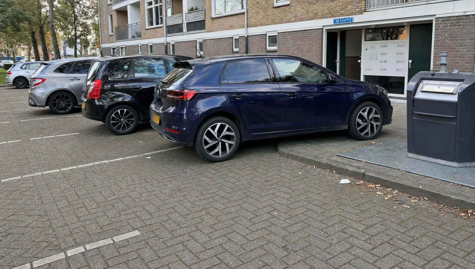 Geparkeerde auto’s in een stadsparkeerstraat tonen hoe velgbescherming helpt tegen stoeprandschade en vuil.